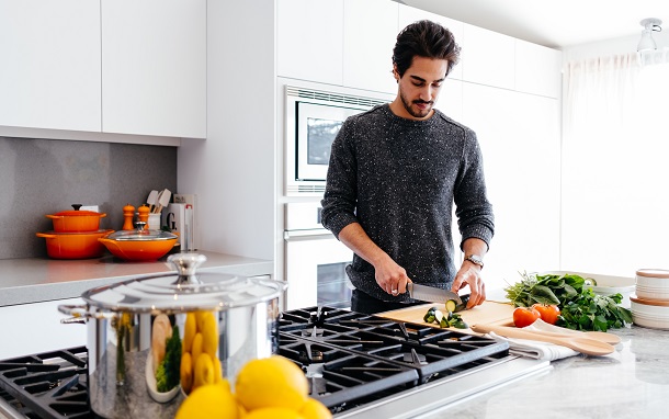 man with knife in kitchen