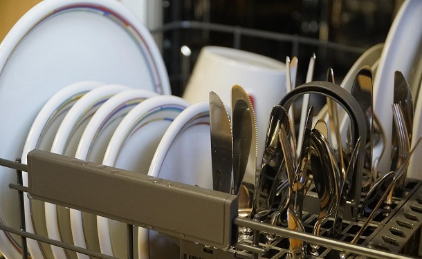 plates and cutlery in the dishwasher loaded