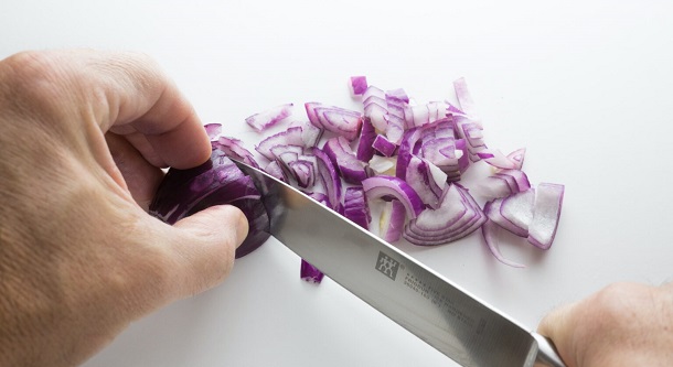 cutting-onion on white countertop
