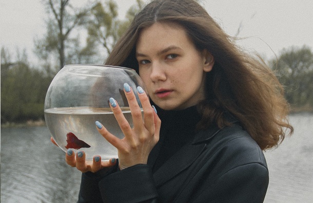 woman holding betta fish bowl